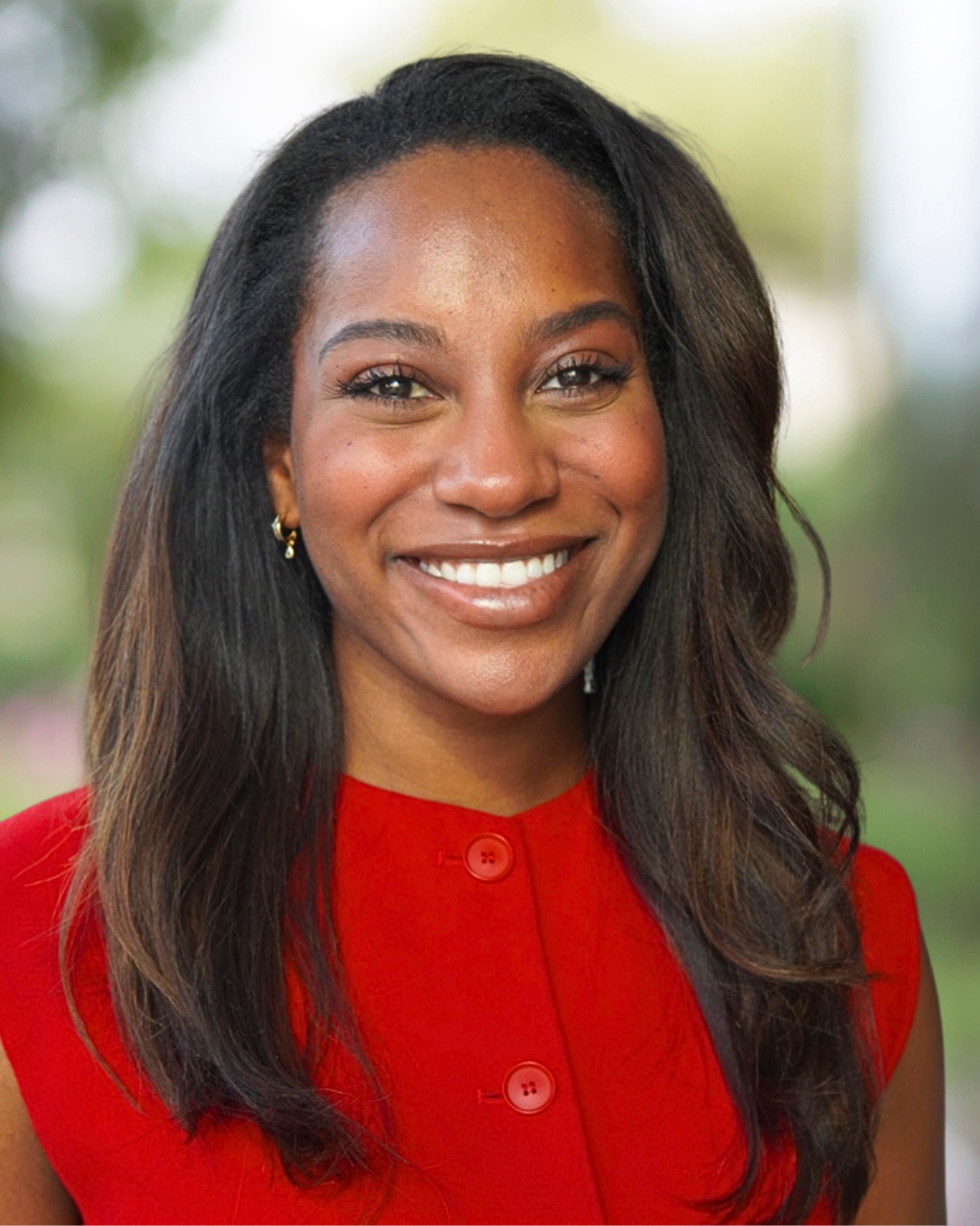 Kameron Buckner smiling in a red dress